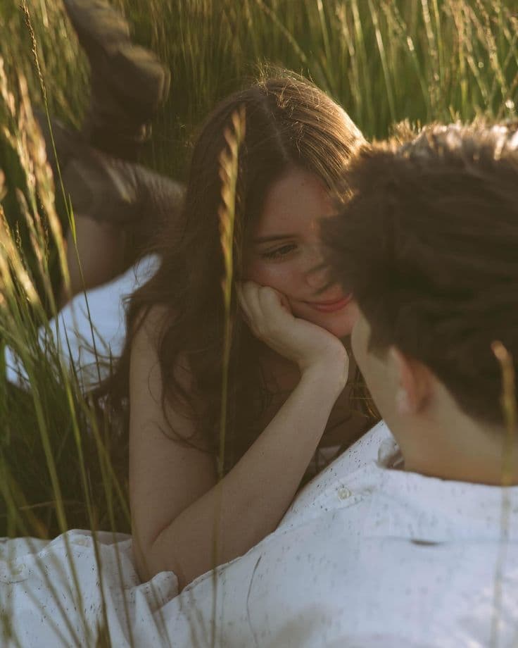 A couple lying together in a sunlit field